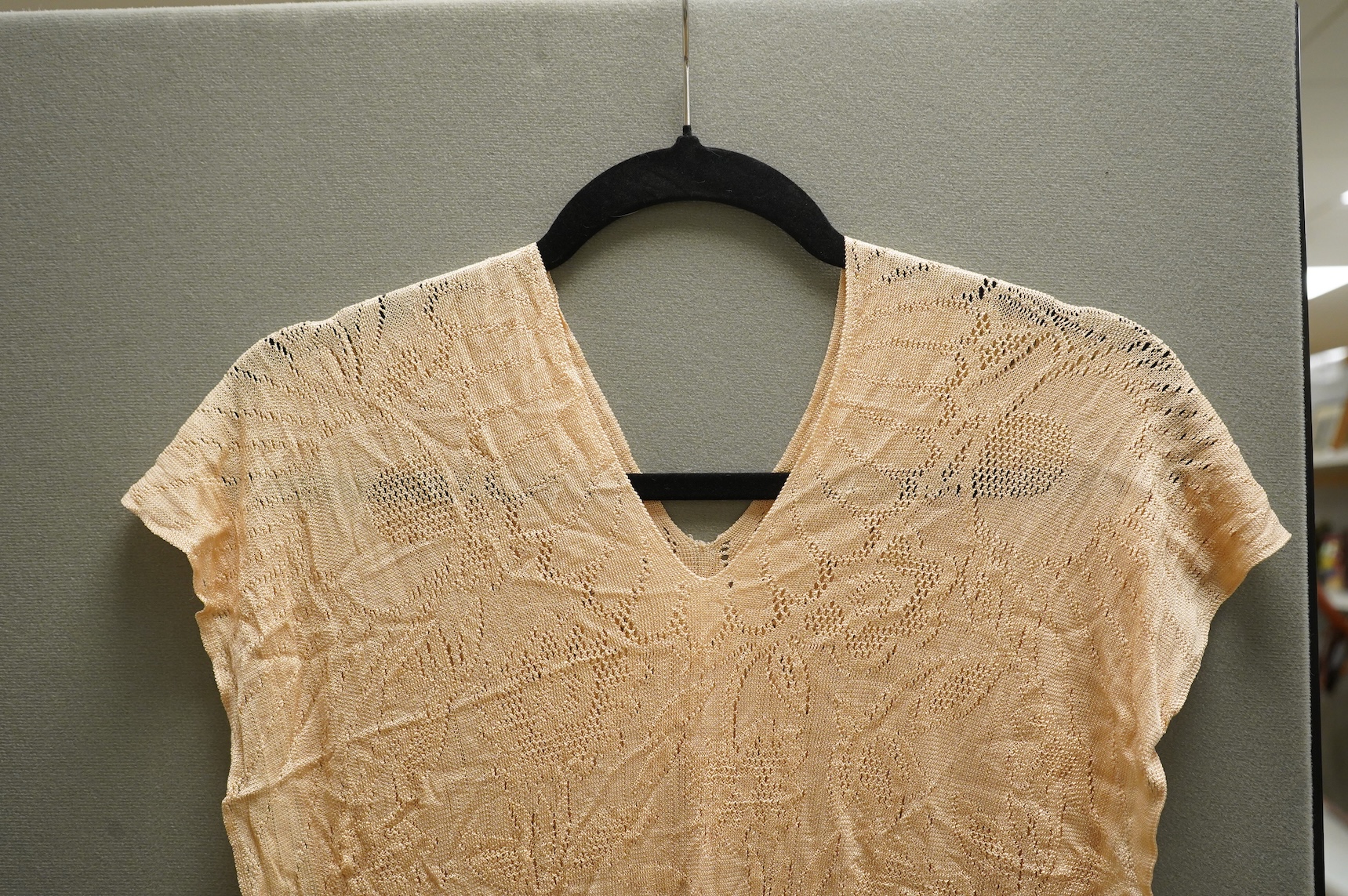 A 1920’s-30’s silk stockinette fringed ladies open sided knitted tabard, sides 56cm long not including fringe. Condition - front point of V slightly worn.